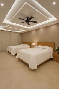 een slaapkamer met 3 bedden en een plafondventilator bij Costta Loft L1 - Santa Cruz in Santa Cruz Huatulco +27 foto's