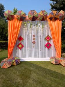 an orange curtain with umbrellas in a yard at Shree farms in Delhi