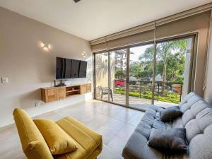 een woonkamer met een bank en een tv bij Costta Loft L1 - Santa Cruz in Santa Cruz Huatulco