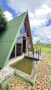 a small house with a green roof and a deck at Rancho Pouso da Gaivota in Muçuroca
