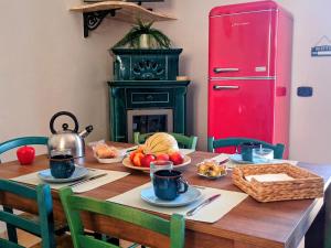 a dining room table with food and a red refrigerator at Polizzihouse in Polizzi Generosa +19 photos