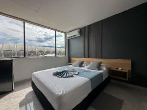 a bedroom with a large bed and a large window at Apartaestudio Moderno San Fernando Sector Estadio in Cali