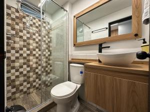 a bathroom with a toilet and a sink and a shower at Apartaestudio Moderno San Fernando Sector Estadio in Cali