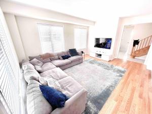 Una sala de estar con un sofá y un televisor. en Two Adjacent Modern Homes in West Niagara Sleep 16, en Thorold