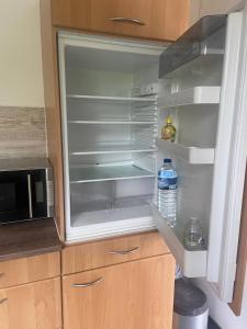 an empty refrigerator with a bottle of water in it at A6 Apartment Wadgassen in Wadgassen