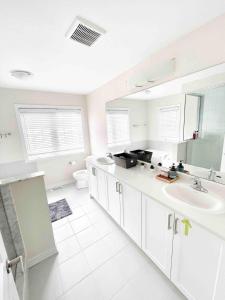 Un baño blanco con lavabo e inodoro. en Two Adjacent Modern Homes in West Niagara Sleep 16, en Thorold