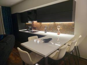 a kitchen with a white table and white chairs at Blu Petrolio Stay-Karabas Apartments in Vicenza