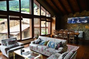 ein Wohnzimmer mit einem Sofa, Stühlen und einem Tisch in der Unterkunft Casa Rural al Pirineu in Ansobell