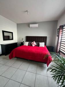a bedroom with a bed with a red blanket at Residence in Chihuahua in Chihuahua