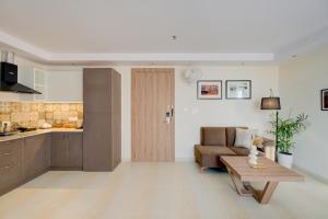 a kitchen and a living room with a couch and a table at Lumi Stays- Luxurious Studio Apartment in Ghaziabad