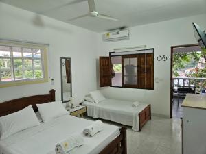 a hotel room with two beds and a balcony at Hotel Refugio Bike in Mariquita