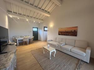 a living room with a couch and a table at Prima Luce in San Donato in Poggio