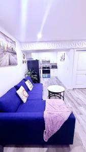 a living room with a blue couch and a table at Modern Comfort Stay Near Airport in Edmonton