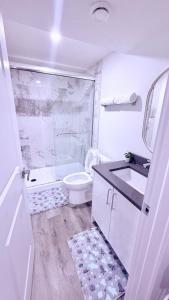 a white bathroom with a toilet and a sink at Modern Comfort Stay Near Airport in Edmonton +18 photos