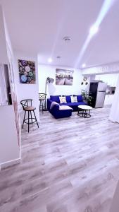 a living room with a blue couch and a tv at Modern Comfort Stay Near Airport in Edmonton
