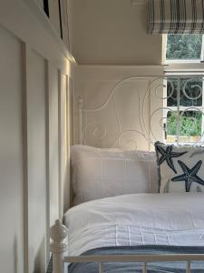 a bedroom with a white bed and a window at Emma's Cottage in Glenarm