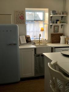 eine Küche mit Spüle und Kühlschrank in der Unterkunft Emma's Cottage in Glenarm