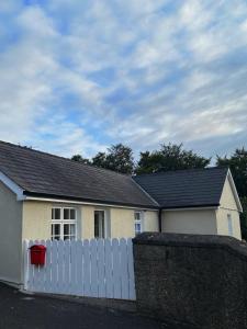 una casa bianca con una recinzione e un tetto nero di Emma's Cottage a Glenarm Altre 4 foto