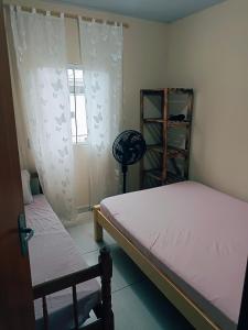 a bedroom with two beds and a window at Le case Rosse in Itapoa +12 photos