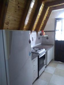 een keuken met een witte koelkast en een fornuis bij Alpinas El Chusmo 2 in Villa Ciudad Parque
