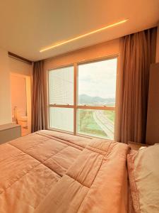 a bedroom with a large bed and a large window at Luxury with Spa at Marina Beach Towers in Balneário Camboriú +57 photos