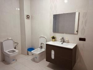 Un baño con inodoro, lavabo y espejo. en Apartment 3 min airport sania ramel tetouan, en Tetuán