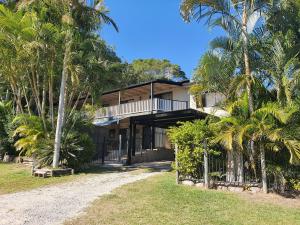 a house with palm trees in front of it at Double Island Dream - Rainbow Beach in Rainbow Beach