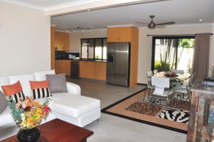 a living room with a white couch and a kitchen at Double Island Dream - Rainbow Beach in Rainbow Beach