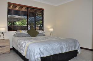 a bedroom with a large bed and a window at Double Island Dream - Rainbow Beach in Rainbow Beach