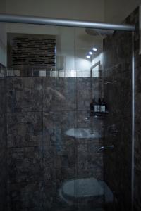 ein Badezimmer mit einer Glasdusche mit Waschbecken in der Unterkunft La Chuklla, alojamiento cerca al lago in Almafuerte