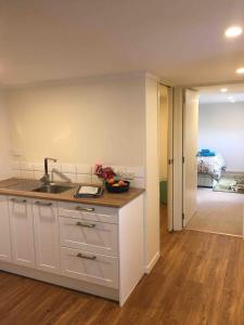 Una cocina con fregadero y una habitación con cama. en Otumoetai 2 bedroom, en Tauranga