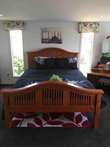 1 dormitorio con cama de madera y osito de peluche en Otumoetai 2 bedroom, en Tauranga