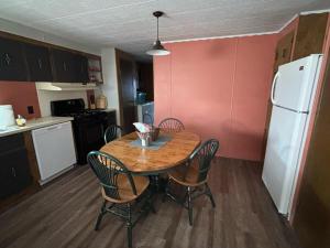 a kitchen with a table and chairs and a white refrigerator at Dorothy's Hideaway in Hulett