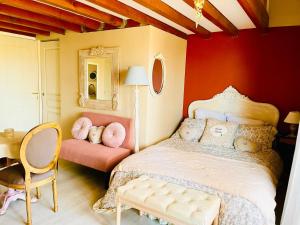 a bedroom with a large bed and a chair at Le Boudoir, inclus petit déjeuner in Quincié-en-Beaujolais