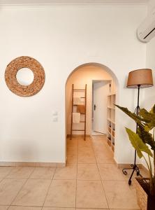 a hallway with an archway and a room with a lamp at Quinta das palmeiras - Aldeia do Pico in Grândola