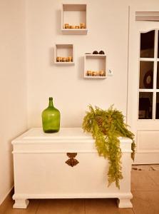 a white chest with a green vase on it at Quinta das palmeiras - Aldeia do Pico in Grândola