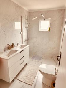 a white bathroom with a sink and a toilet at Quinta das palmeiras - Aldeia do Pico in Grândola +10 photos