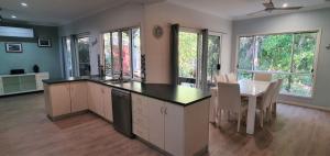 a kitchen and dining room with a table and chairs at Shelleys - Rainbow Shores in Rainbow Beach +6 photos