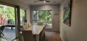 a dining room with a table and a large window at Shelleys - Rainbow Shores in Rainbow Beach