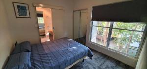 a bedroom with a bed and a large window at Shelleys - Rainbow Shores in Rainbow Beach