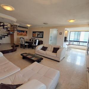 a living room with two white couches and a table at Terraza del Sol in Macuto +66 photos