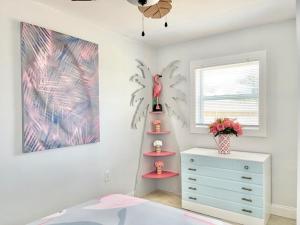una camera da letto con una cassettiera e un uccellino rosa su uno scaffale di Flamingo Cottage 2 bedroom a Jensen Beach