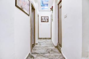 a hallway with a white door and a tile floor at Hotel O Bine Venue in Bhopal