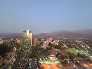 a city with cars parked in a parking lot at Apart Manquehue in Santiago