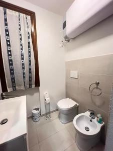 a bathroom with a white toilet and a sink at Casa Smeraldo in Cavo +22 photos