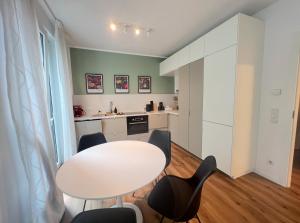 a small kitchen with a white table and chairs at Dimoro Family Suites - Designed for your comfort in Essen