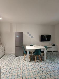 a kitchen with a table and chairs and a refrigerator at Casa Smeraldo in Cavo