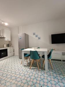 a kitchen with a white table and four chairs at Casa Smeraldo in Cavo