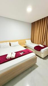 a bedroom with two beds with red and white towels at Hotel Vision Guaianases in São Paulo +12 photos