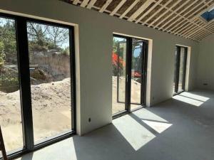 een lege kamer met grote ramen in een huis bij HS001-Henne-Enebaervej-6 in Henne Strand